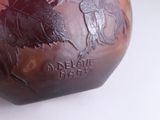 a brown vase with a picture of a man riding a horse