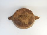 a small wooden bowl with a handle on a white surface