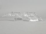 une paire de figurines d'animaux en verre transparent posées sur une surface blanche