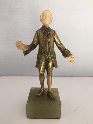 statue of a man in a suit and tie standing on a base