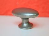 a silver knob on a white table with a red background