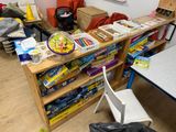 a room with a table, chair, bookshelf, and other items on the floor
