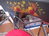 a table with a red chair and a painting on it