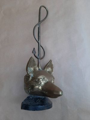 une tête de chien en métal suspendue à un crochet fixé au mur