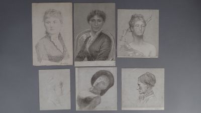 Six portraits différents de femmes sont accrochés au mur d'une pièce.