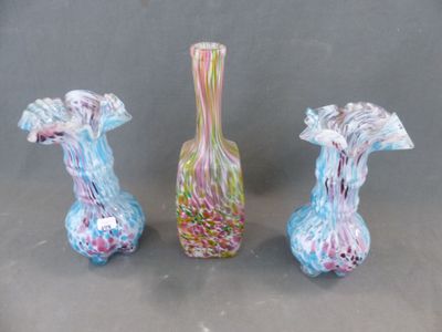 trois vases en verre posés l'un à côté de l'autre sur une table