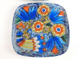 a blue plate with flowers on it next to a cup