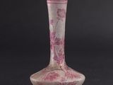 pink and white vase on a black surface with a black background