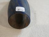 a blue vase with a tag on it sitting on a white surface