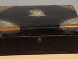 une petite boîte noire ornée d'un motif doré