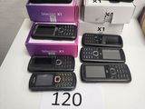 Plusieurs téléphones portables sont posés sur une table, accompagnés d'une étiquette de prix