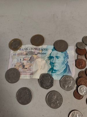 une pile de pièces et un billet de banque posés sur une table