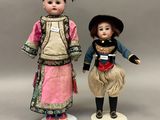 une paire de poupées en porcelaine représentant un garçon et une fille en costume traditionnel