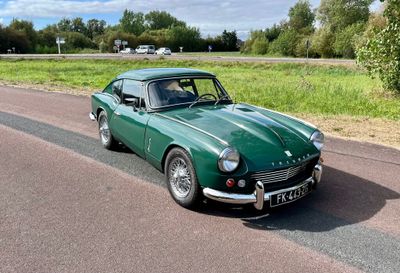 une voiture verte qui roule sur la route par une journée ensoleillée