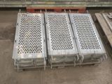several steel grates stacked on top of each other in a warehouse