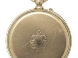 une vieille montre de poche en or avec une chaîne, sur fond blanc