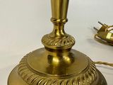 a gold table lamp that is on a white table
