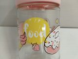 a glass jar with a pink lid on a table