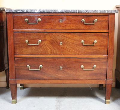 a wooden dresser with marble top in a room
