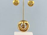a gold sculpture on a marble stand on a table