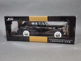 an old black car in a box on a gray surface
