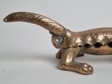 a gold cat figurine sitting on a white surface