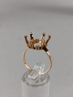 a close up of a gold ring on a clear surface