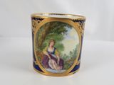 a close up of a cup with a painting on it