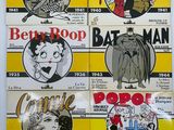 several comics are on display on a wall in a room