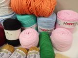 many balls of yarn sitting on a table next to a cutting board