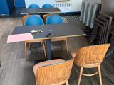 tables and chairs are lined up in a restaurant with a blue brick wall