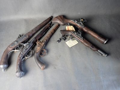 Plusieurs vieilles armes sont posées sur une table, accompagnées d'étiquettes.
