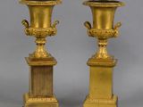 une paire de vases anciens en laiton sur socles, sur fond gris