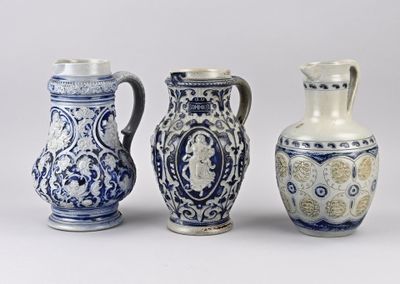 trois vases bleus et blancs posés les uns à côté des autres sur une surface blanche