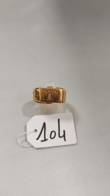 une image d'une bague en or sur une surface blanche avec une étiquette de prix