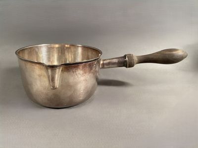 a silver bowl with a wooden handle on a table