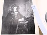 une photo d'une femme assise sur une chaise, un livre ouvert entre les mains