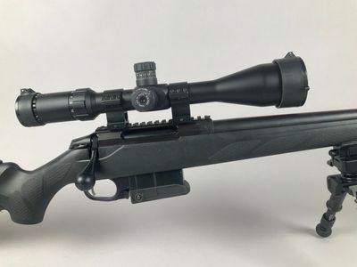 a rifle on a tripod with a scope on it