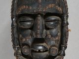 an image of a wooden mask hanging on a wall