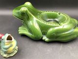 a green frog shaped ashtray with a small frog figurine next to it