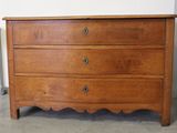 une commode en bois dans une pièce équipée d'un radiateur