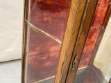 an antique display cabinet with a glass door and gold trimming
