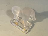 a glass elephant figurine sitting on top of a clear base