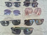 several pairs of sunglasses are on a table with a price tag