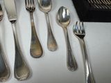 a lot of silver spoons and silverware on a table