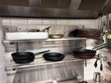 many pots and pans on the shelves in the kitchen