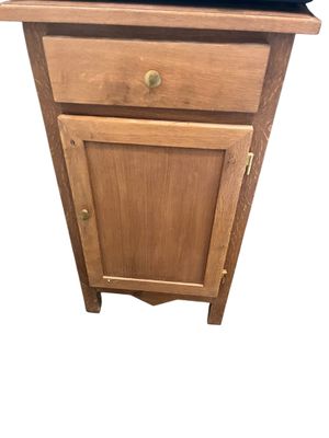 un petit meuble en bois surmonté d'un tiroir