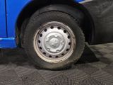 a blue bus with a flat tire on the street