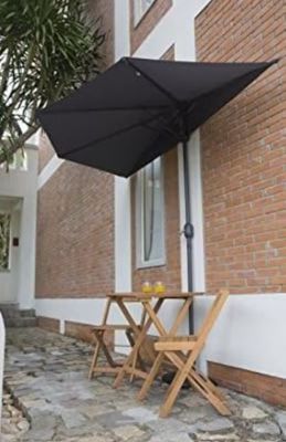 une table et des chaises à l'extérieur d'un bâtiment, surmontées d'un parasol