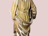 une statue représentant un homme barbu tenant un chien dans ses bras